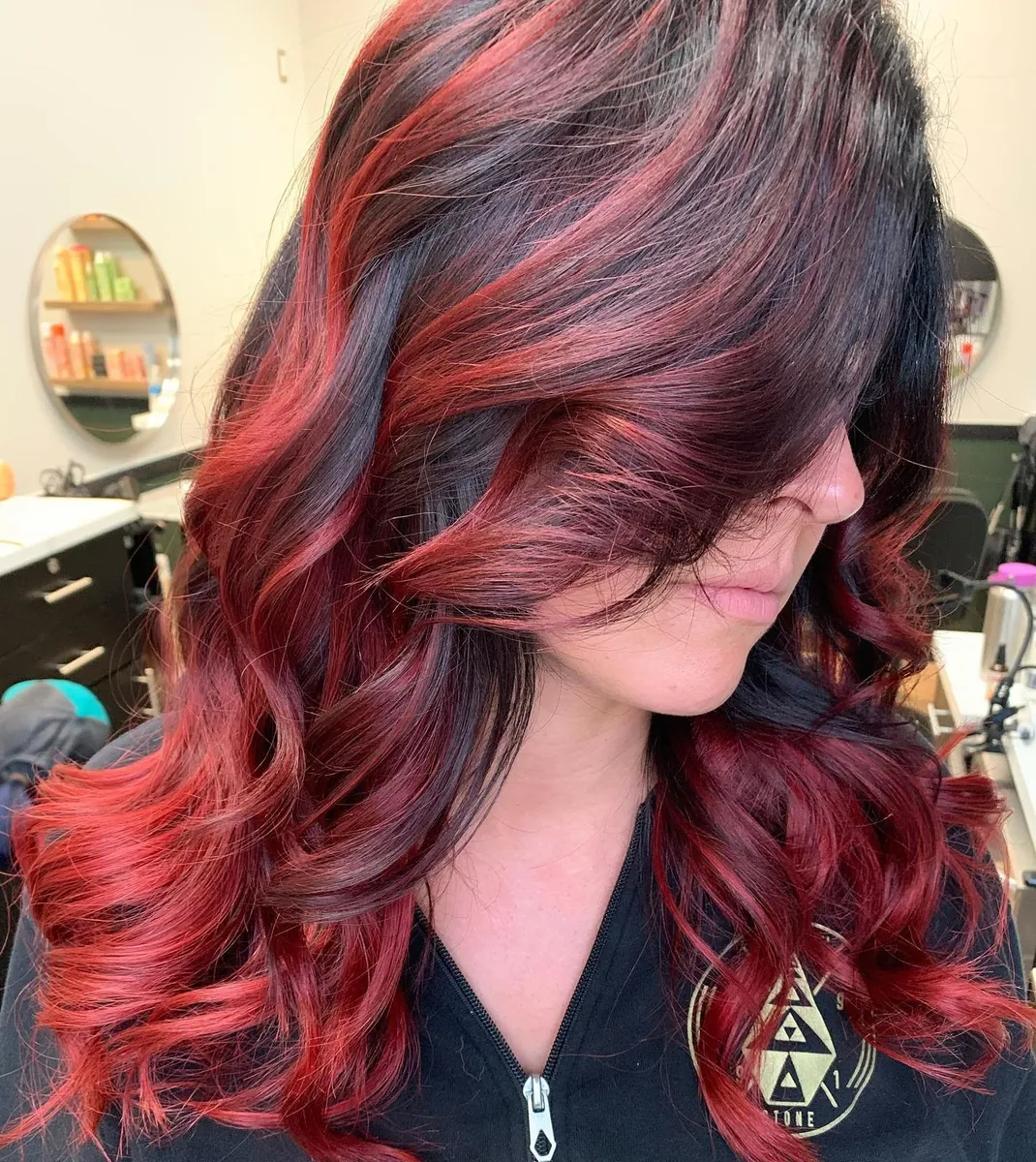Dark hair with bold red dimensional color and curls